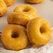 a close up of three almond flour donuts with golden glaze