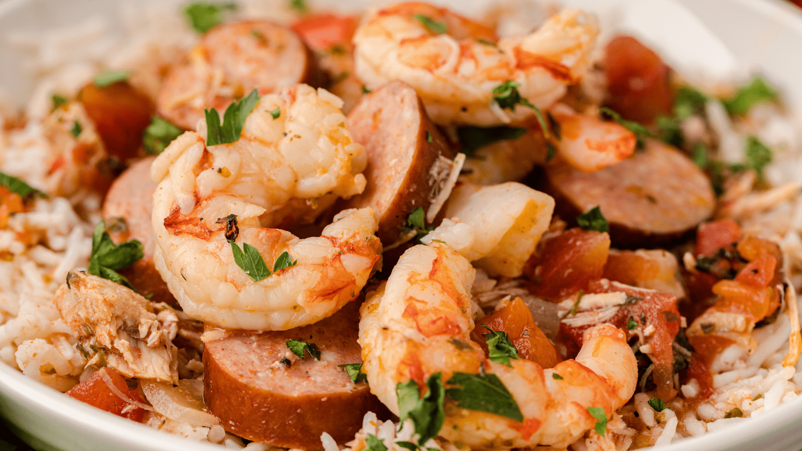 a close up of shrimp and sausage in CrockPot jambalaya on a bed of rice on a plate