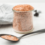 Homemade BBQ Pork Spice Rub in a small glass jar with a spoon