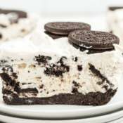 Homemade Oreo ice cream pie on a stack of white plates