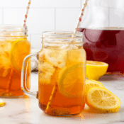 a glass of the best southern sweet iced tea with a pitcher of tea in the background