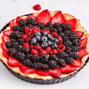 a fruit tart with strawberries, blackberries, raspberries, and blueberries and cream cheese filling