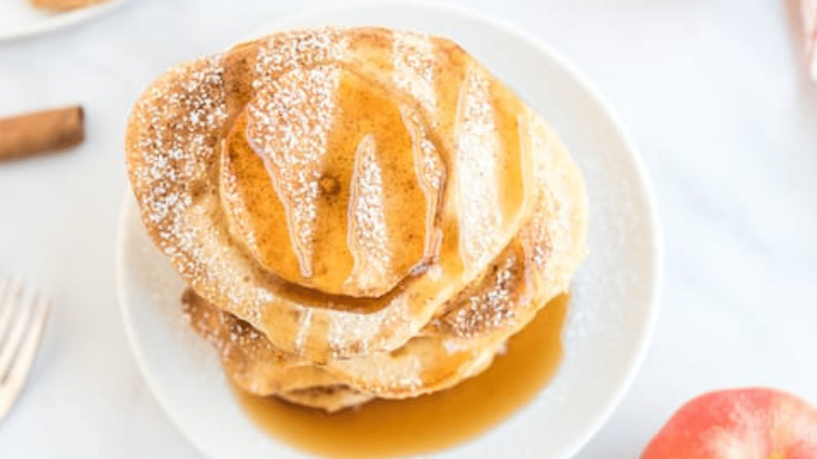 a stack of a close up of apple ring pancakes on a white plate