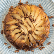 a baked apple pecan pancake with pecans on a metal serving tray