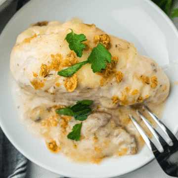 easy Swiss Cheese chicken on a white plate with a fork