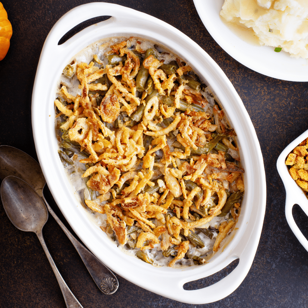 green bean casserole in a baking dish with a serving spoon