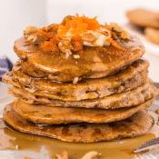 carrot cake pancakes topped with grated carrot and walnuts
