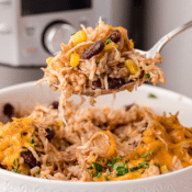 a big spoonful of cheesy chicken and rice in front of an Instant Pot