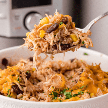 a big spoonful of cheesy chicken and rice in front of an Instant Pot