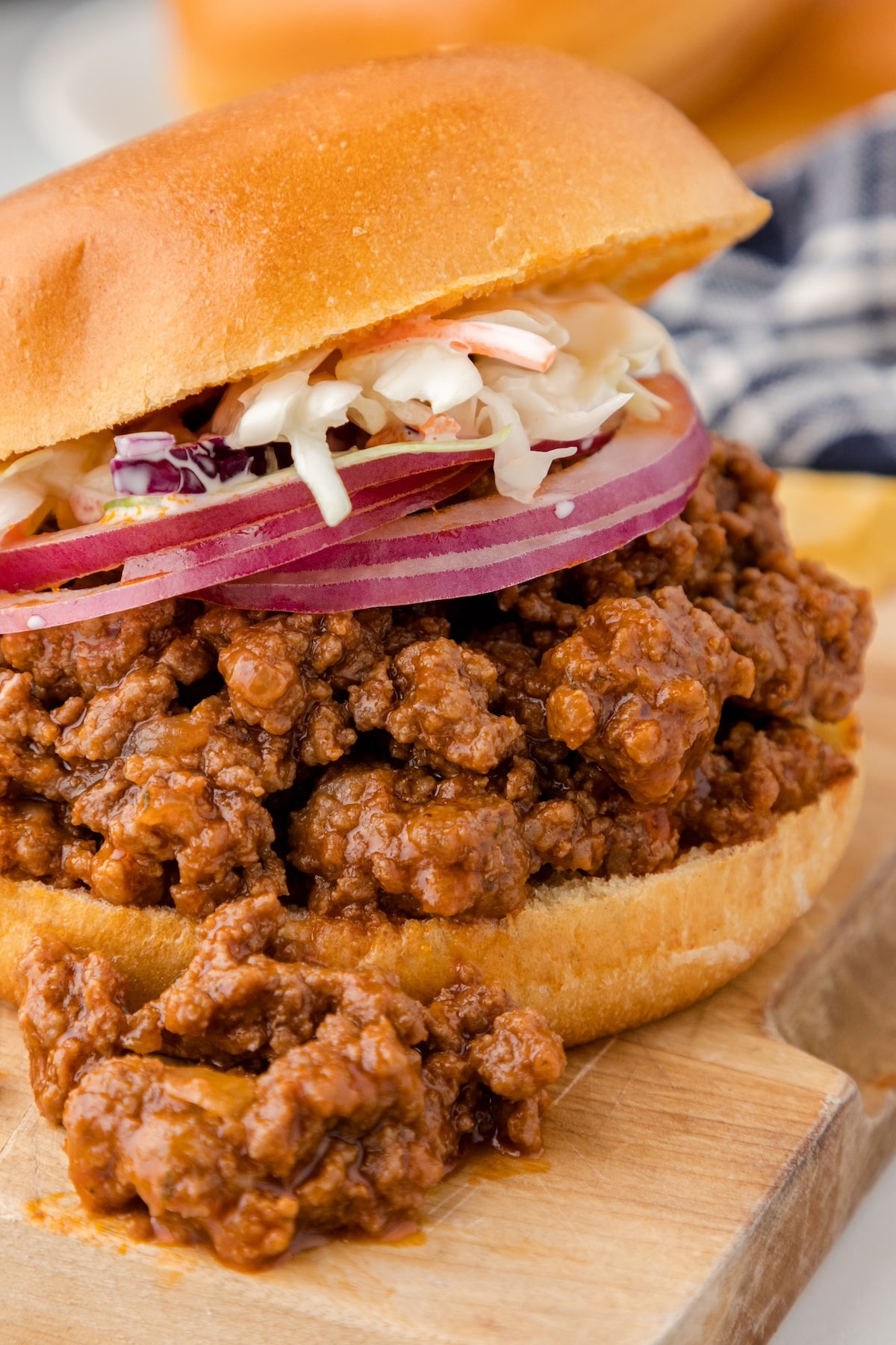 one Instant Pot sloppy joe sandwich with slices of red onion and coleslaw on top