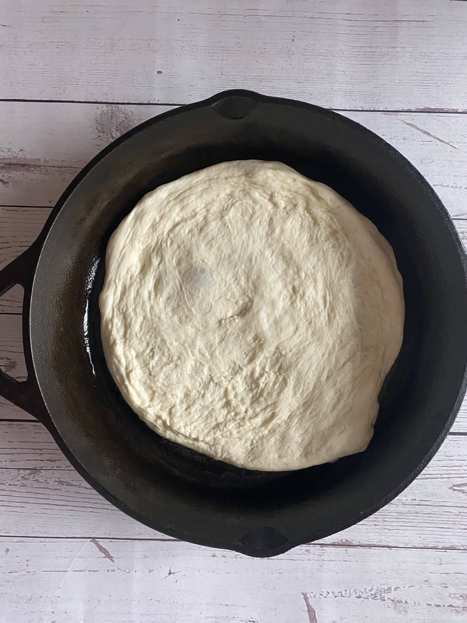 sourdough pizza crust in a cast iron skillet