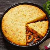 Chili Chicken topped with Cornbread in a black casserole dish