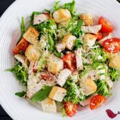 a close up of sauteed chicken salad on a white plate