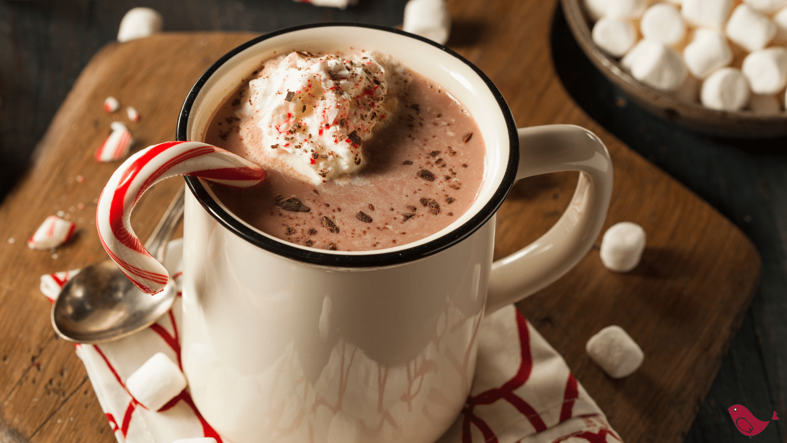 peppermint hot chocolate in a white mug with whipped cream and a candy cane