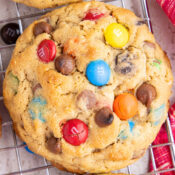 a close up of one Easy Monster Cookies with M&Ms, chocolate chips, peanut butter, and oatmeal on a cooling rack