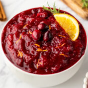 Instant Pot Cranberry Sauce with Orange Juice in a bowl topped with orange zest and fresh cranberries