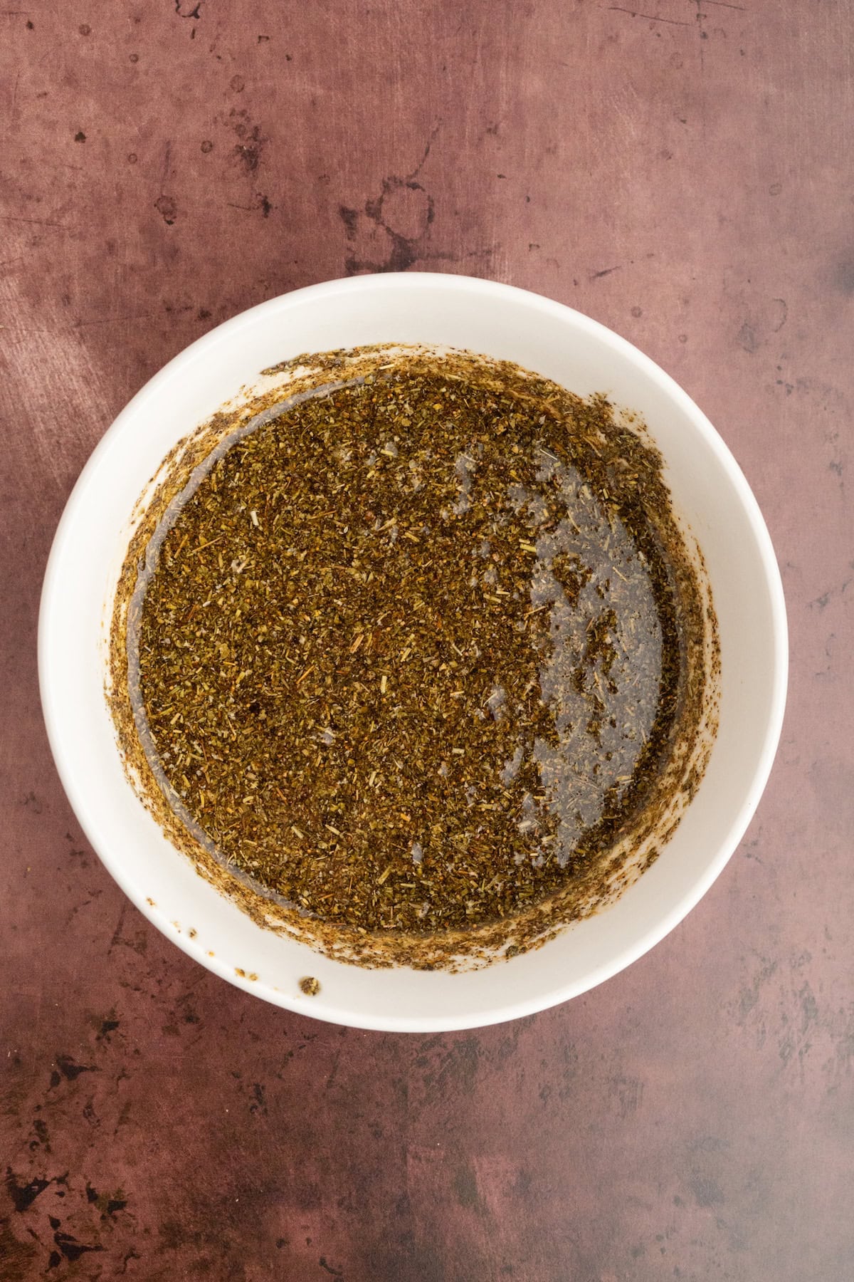 balsamic marinade with herbs in a white bowl