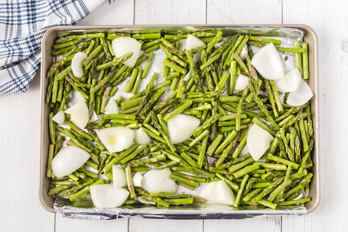 asparagus and onions on a baking sheet before roasting