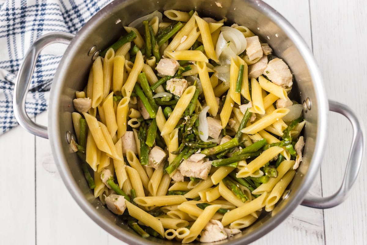 add the cooked pasta to the pot with the chicken and asparagus