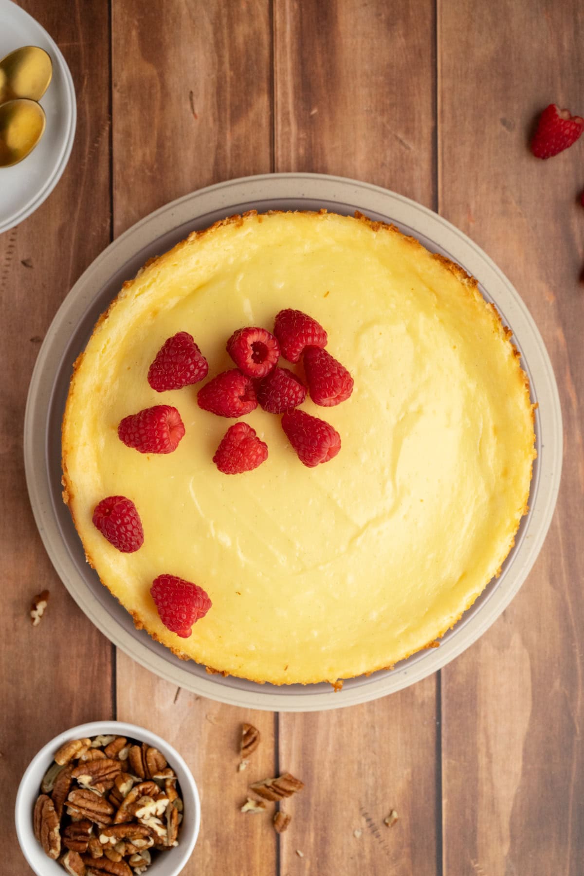 Gluten-Free Pecan Crust Cheesecake topped with fresh red raspberries