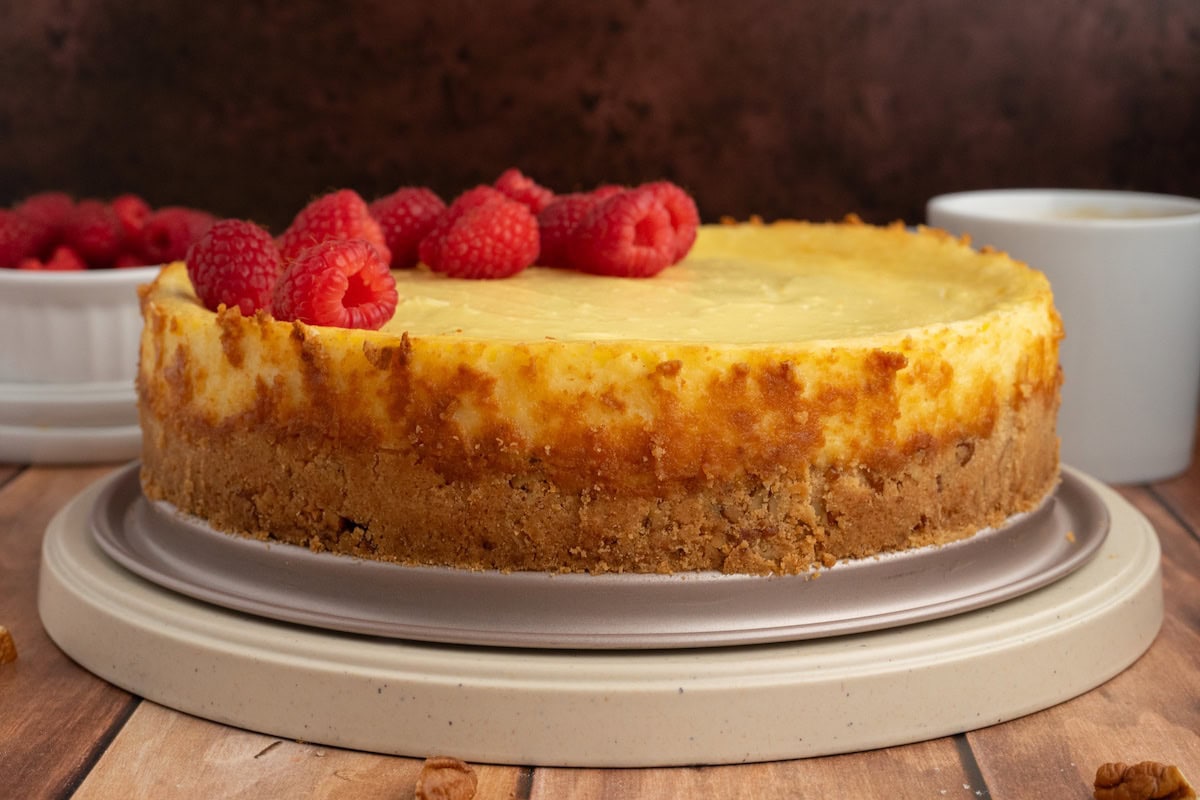 gluten-free cheesecake with a pecan crust topped with fresh raspberries