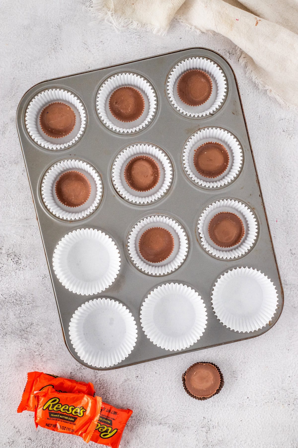 place one Reese's peanut butter cup in the bottom of each cupcake wrapper