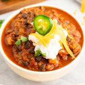 a close up of easy black bean and beef chili in a white bowl