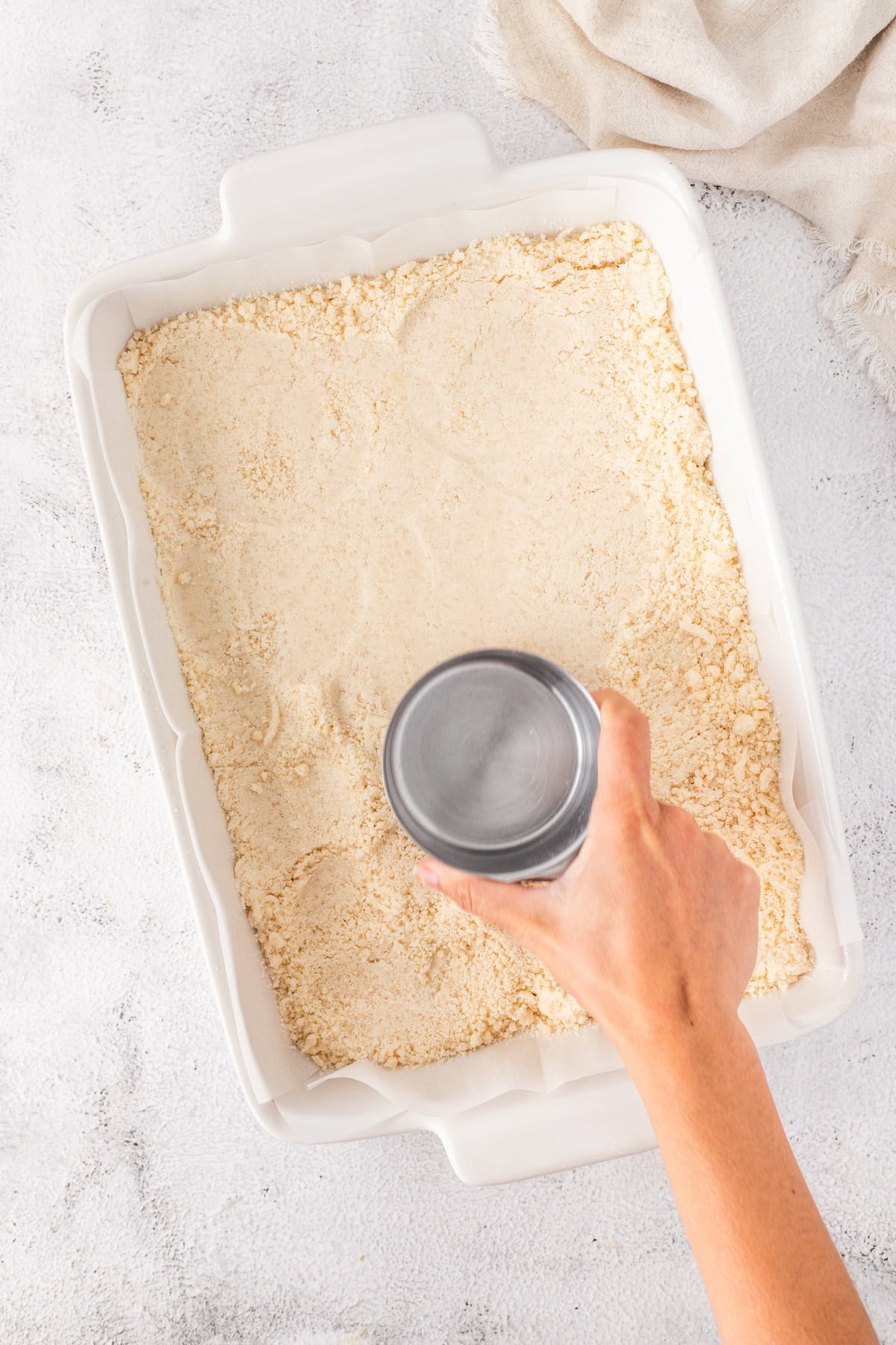 use a measuring cup to smooth out the top of the cookie crust