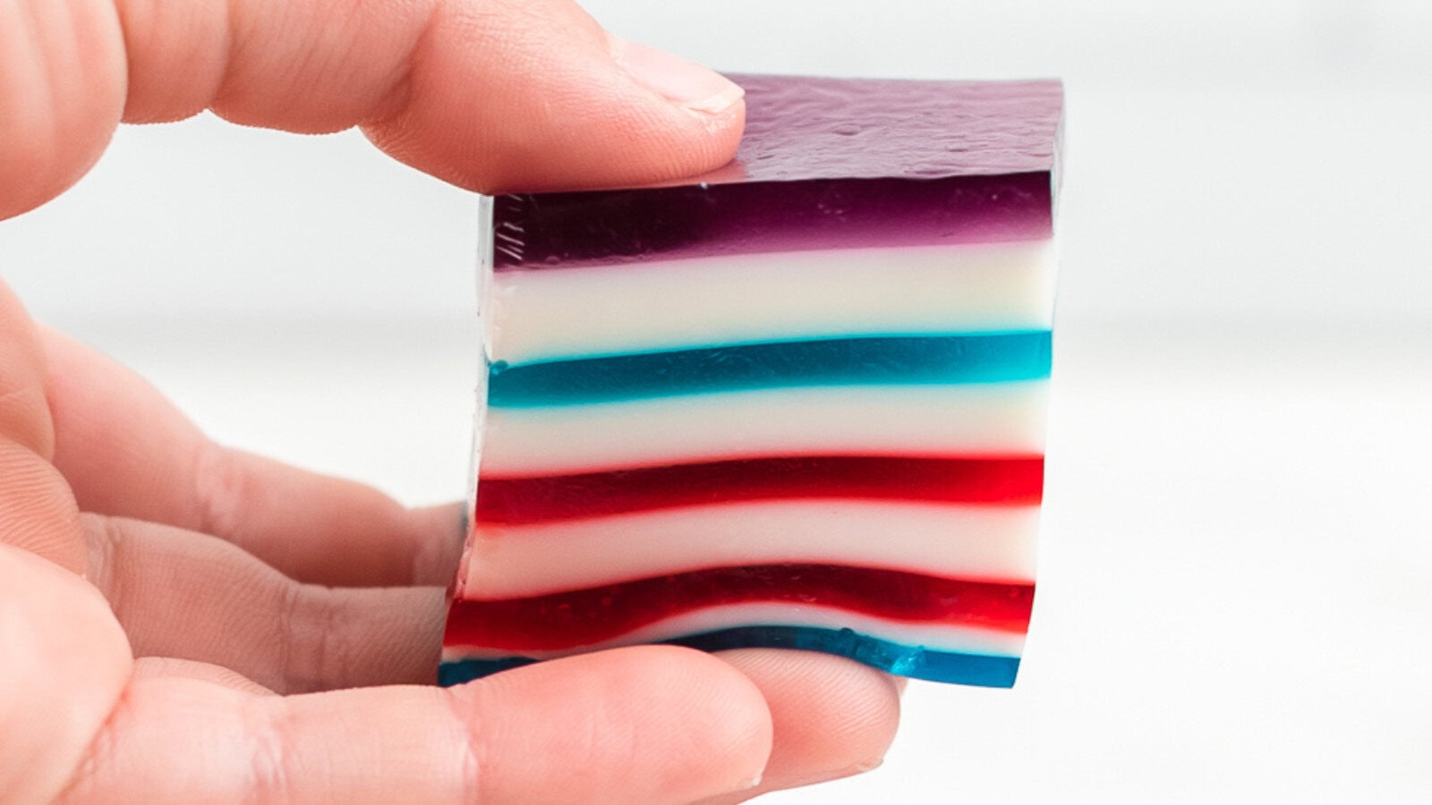 red white and blue layered jello held in fingers