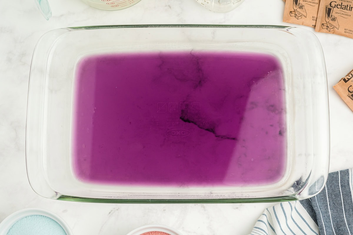 pour the purple liquid jello into the prepared pan