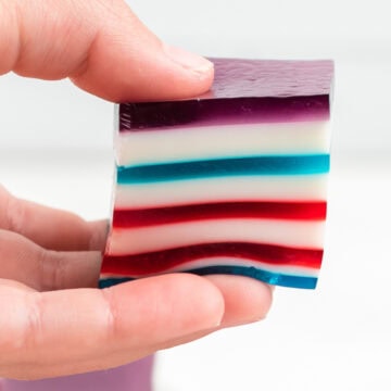 a square of red white and blue layered jello held in fingers