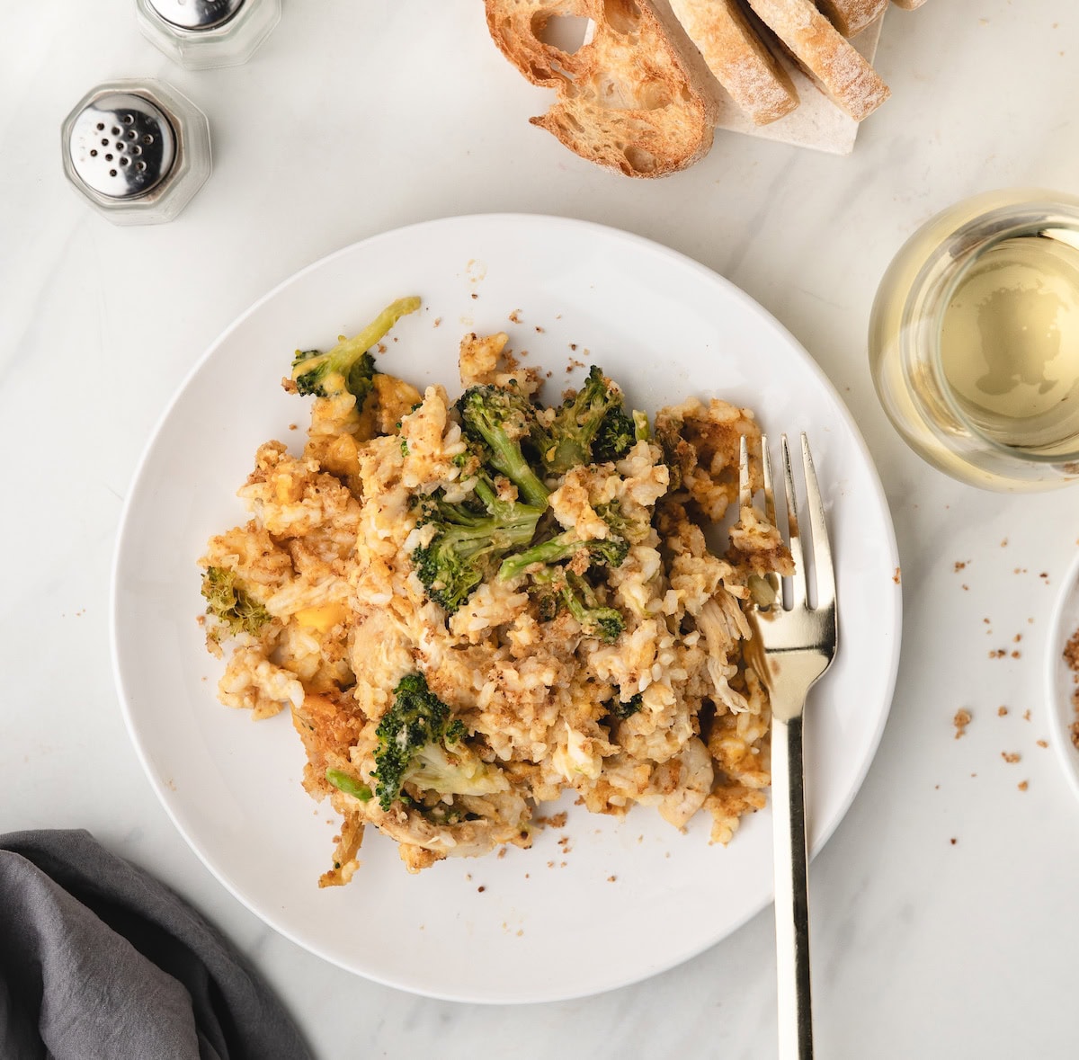 one serving of Chicken Broccoli Rice and Cheese Casserole on a white plate with a fork
