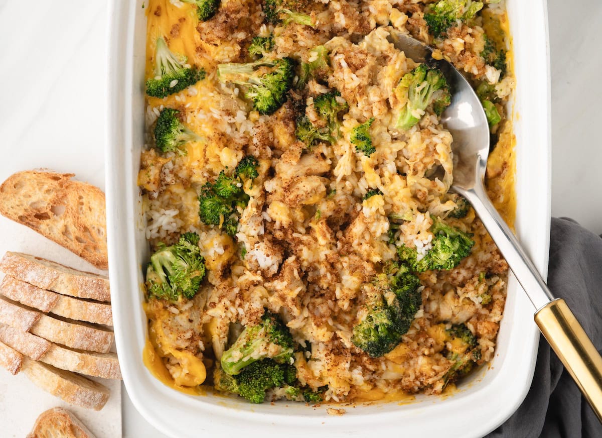a pan of Chicken Broccoli Rice and Cheese Casserole with toasted bread slices