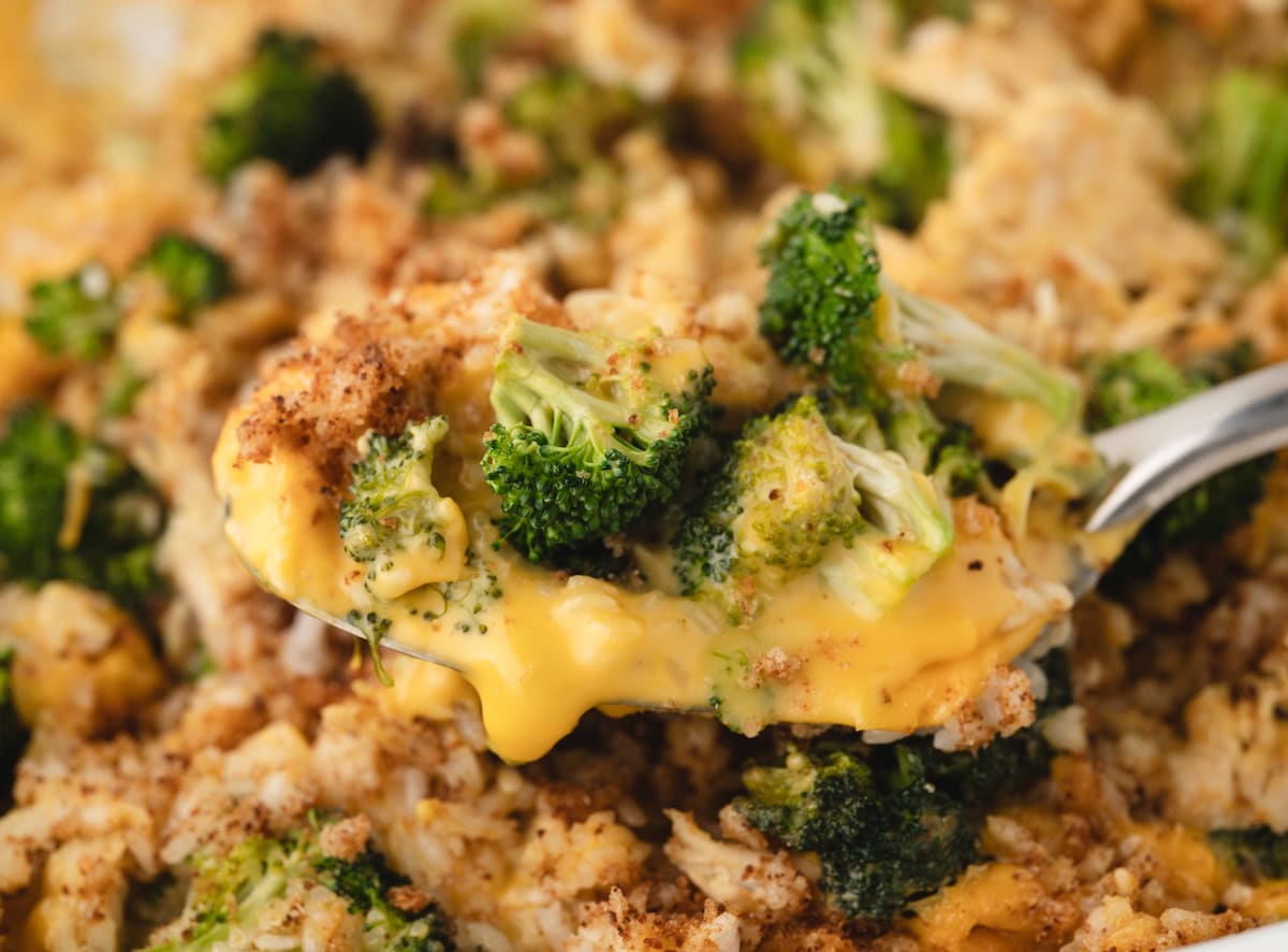 Chicken Broccoli Rice and Cheese Casserole with melted cheese dripping off of the spoon