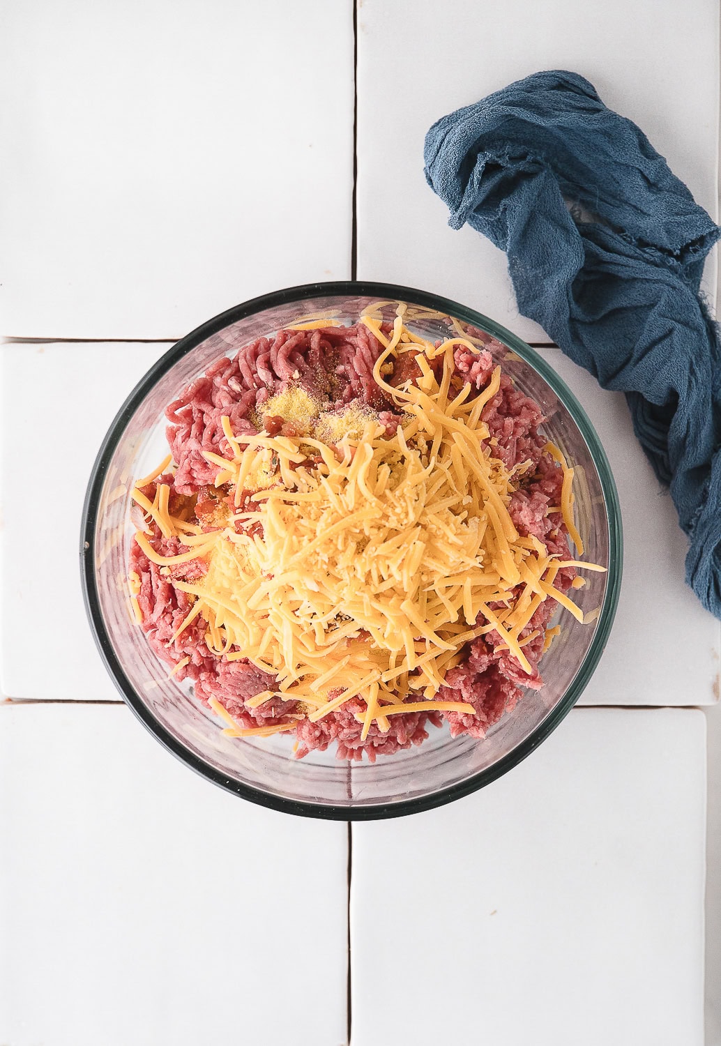 add the shredded cheddar cheese to the taco burger mixture