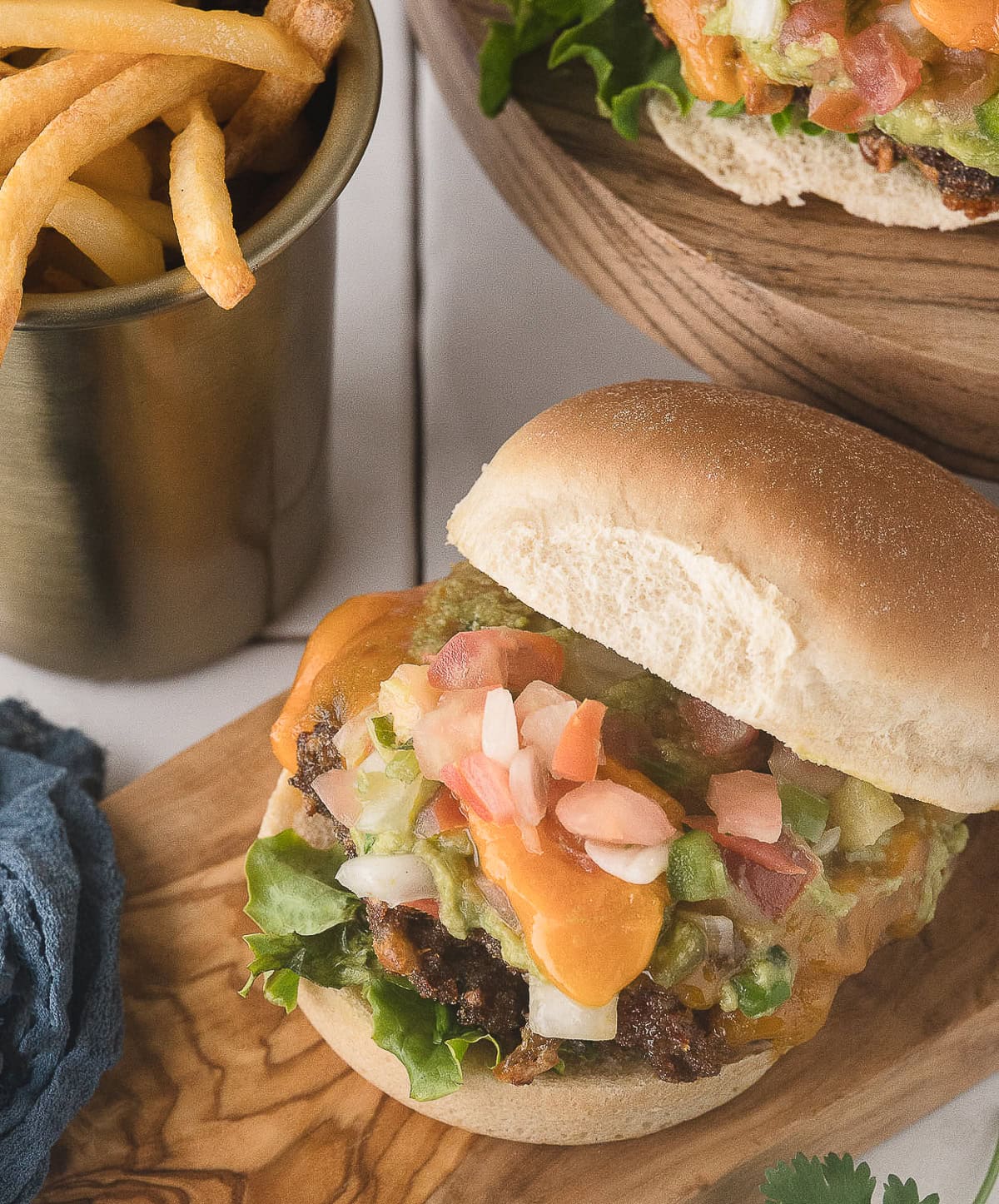 an air fryer burger with taco seasoning, guacamole, cheddar cheese, and salsa
