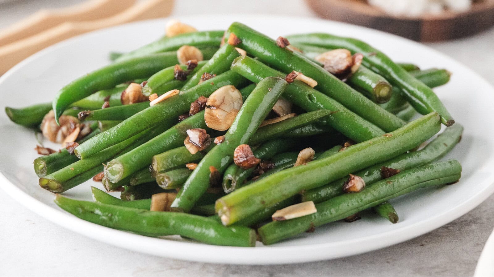Asian green beans with almonds on a white plate