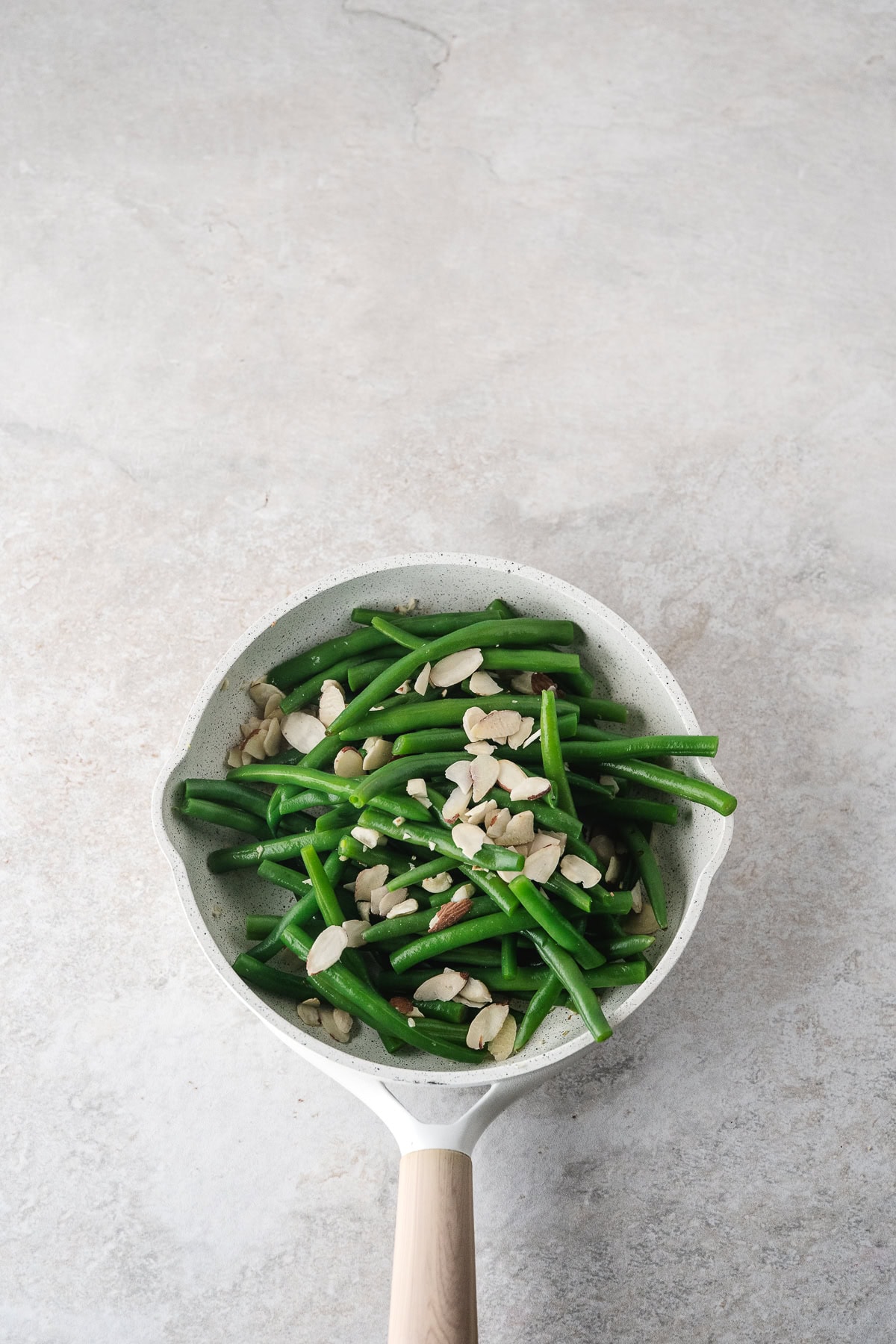 add the green beans and almonds to the garlic in the skillet