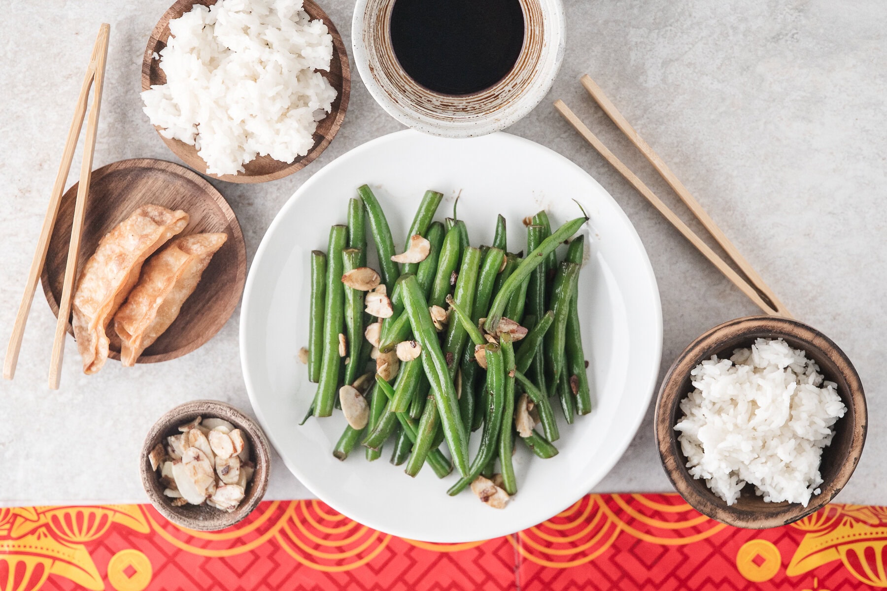 Chinese green beans on a plate with rice and pot stickers