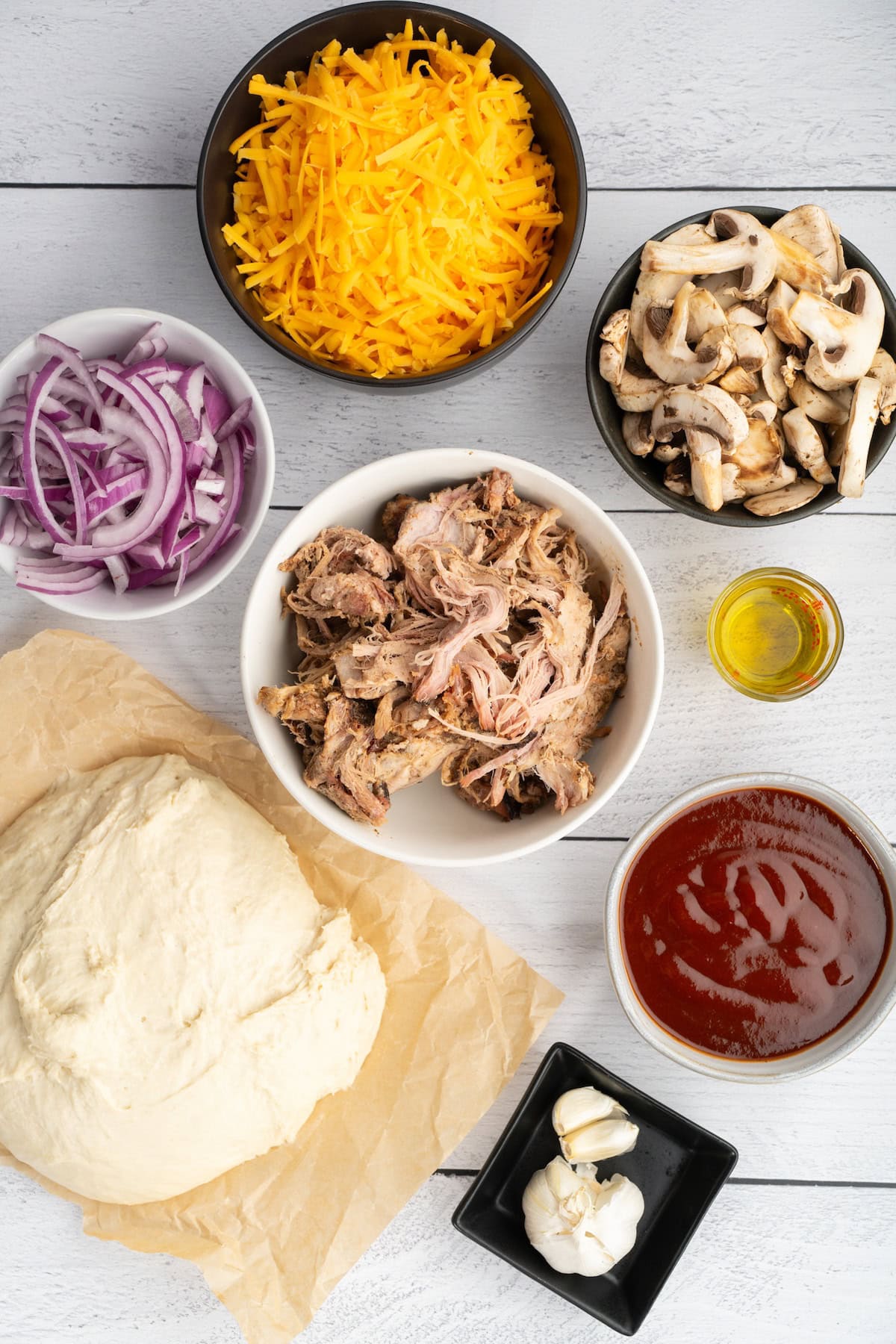 BBQ Pulled Pork Pizza ingredients including leftover pulled pork, BBQ sauce, mushrooms, and red onions