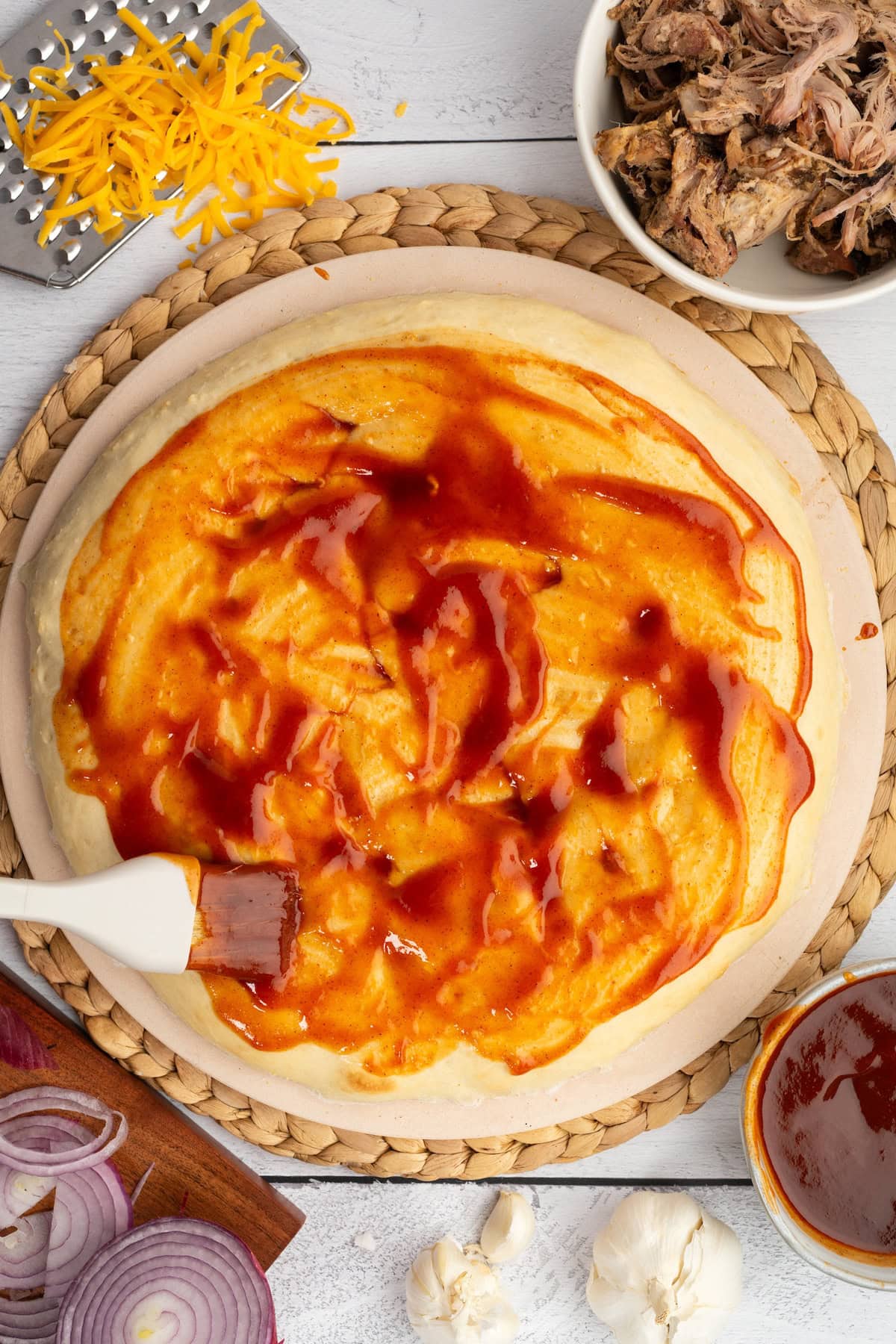spread BBQ sauce on the pre-baked pizza crust