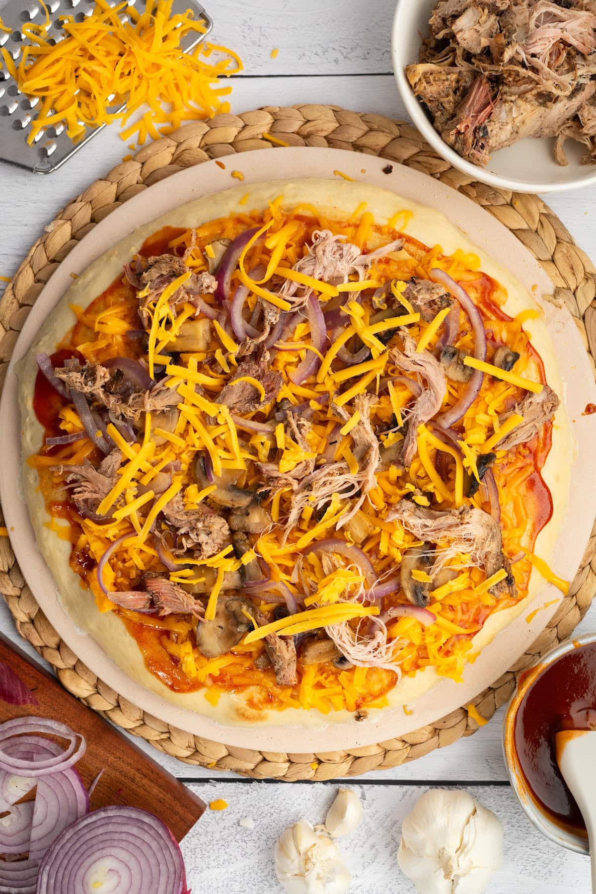 top the BBQ sauce with leftover pulled pork, the sautéed mushrooms and onions, and shredded cheddar cheese