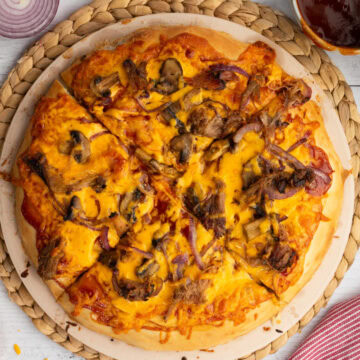 a whole BBQ Pulled Pork Pizza on a pizza stone
