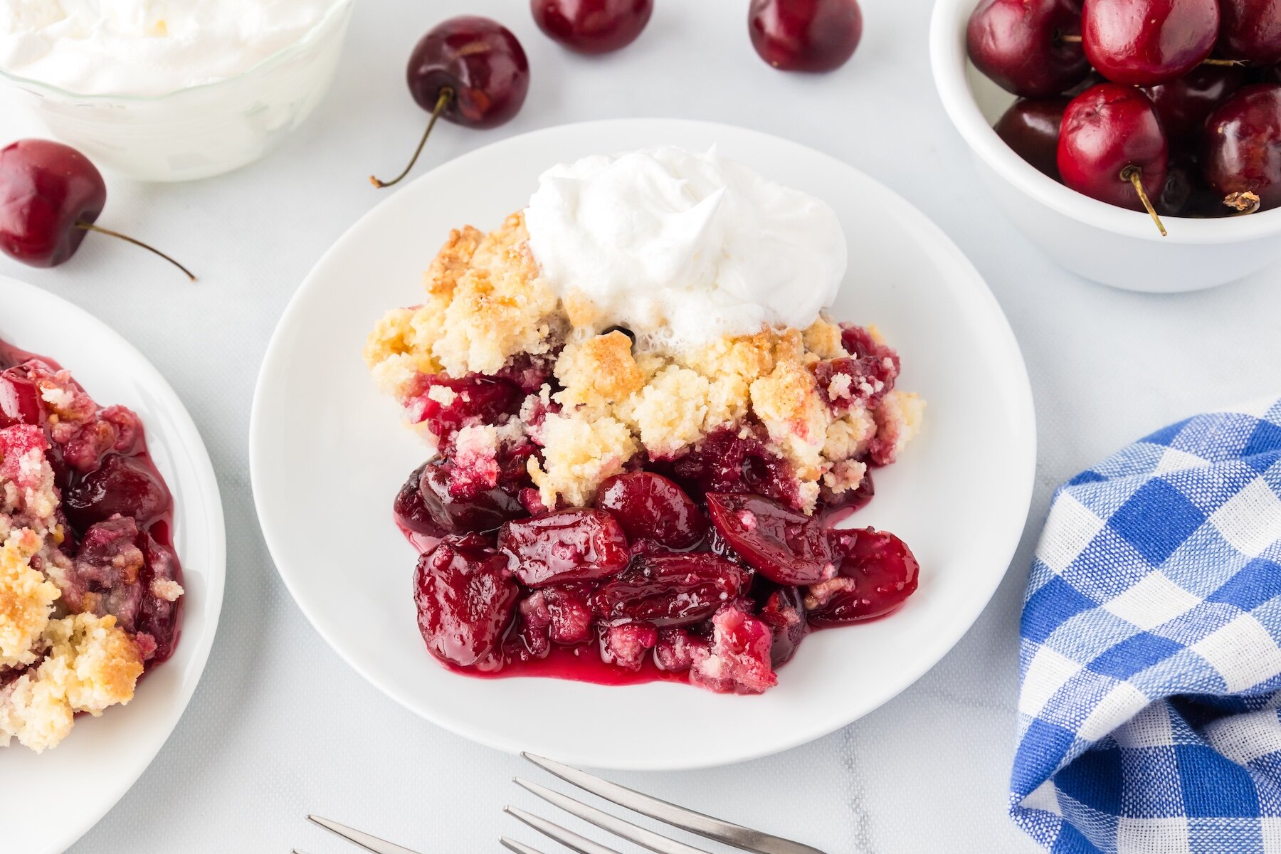 one serving of fresh cherry cobbler topped with whipped cream
