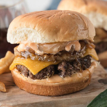 Hawaiian burger topped with grilled pineapple and caramelized onions on a sweet Hawaiian roll and cooked on the stove
