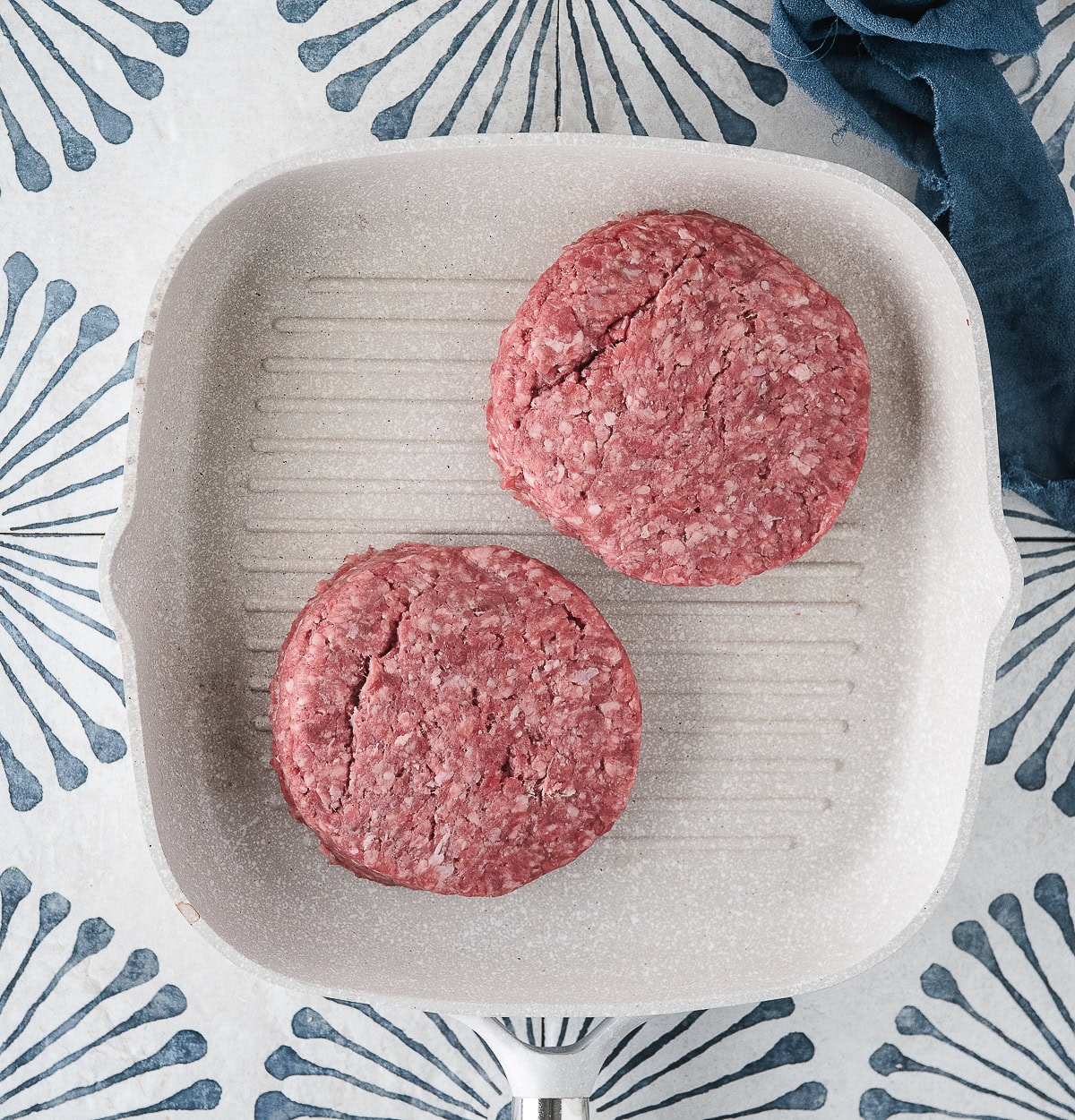 hamburger patties in a grill pan on the stove