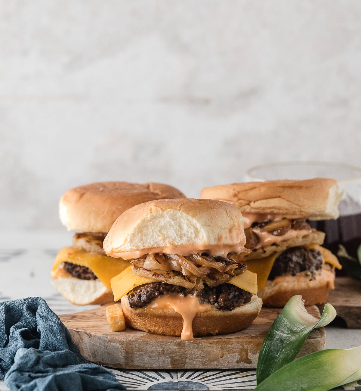 three Hawaiian burgers on a cutting board after cooking on the stove
