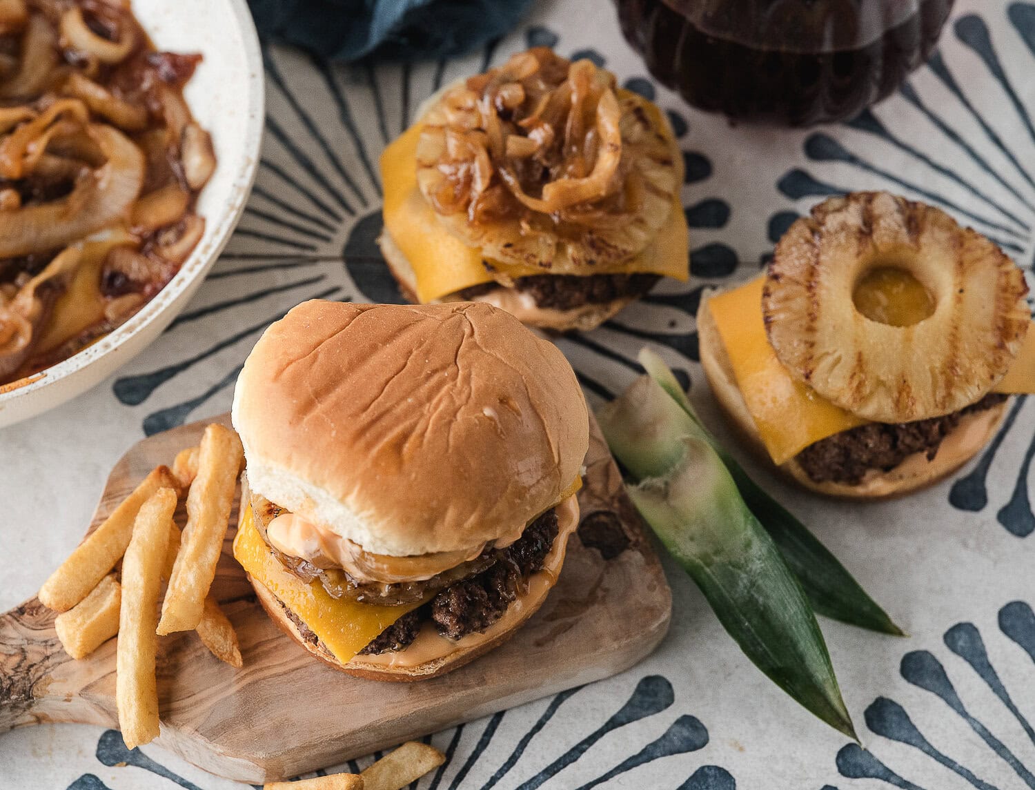three stove top burgers with grilled pineapple and caramelized onions
