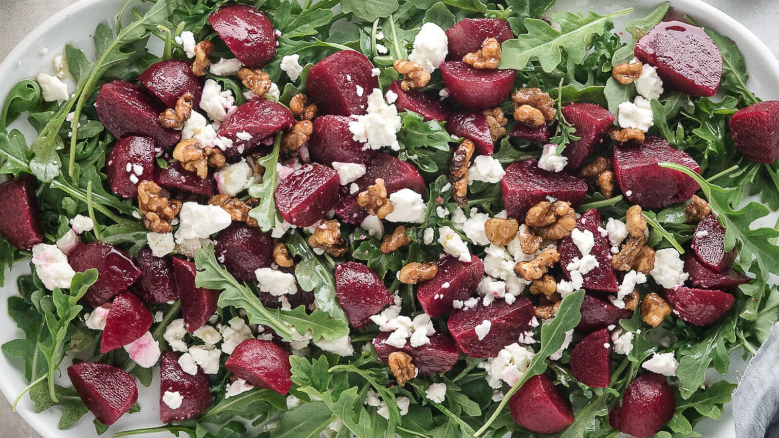 a platter of roasted beet salad with feta and walnuts