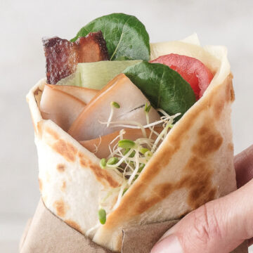 one warm turkey bacon wrap held in a napkin